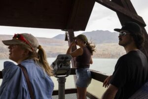 From left, Katie Pellicore, Lauren Oliver and Brett Oliver listen during a presentation on the migratory waterfowl protection program at the Berkeley Pit viewing stand in Butte on July 16. Photo Credit: Megan Nielsen, Montana Standard