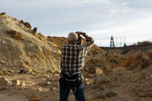 An attendee takes a photo of the Diamond headframe through the wasteland of Berkeley Pit overburden during a tour led by CTEC to the historic Pilot Butte Mine in Butte on Sept. 17. MEGAN NIELSEN, Montana Standard